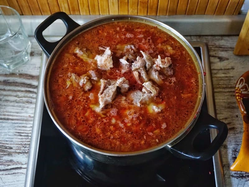Борщ малороссийский Густой малороссийский борщ с кусками мяса в глиняной миске