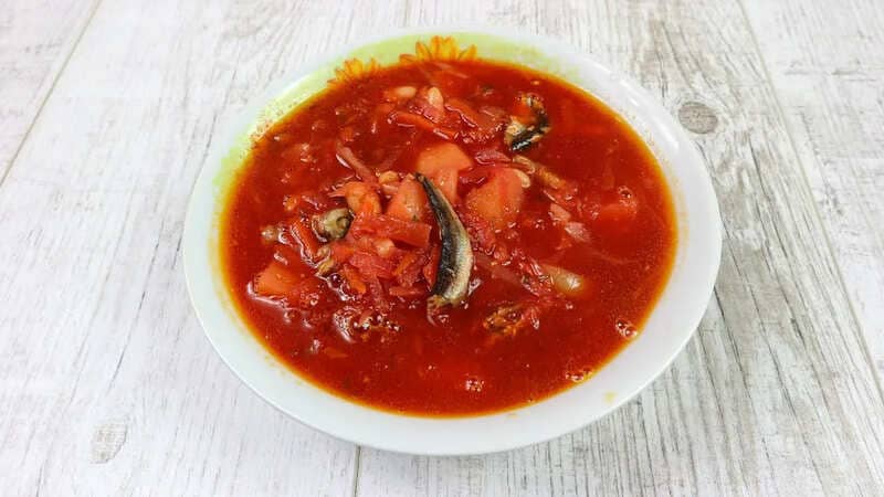 Домашний борщ с килькой и фасолью Борщ с килькой в томате и фасолью в тарелке с зеленью и сметаной